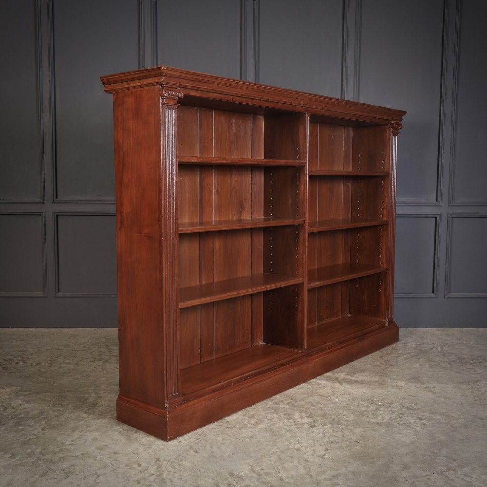 A large Victorian open oak bookcase featuring two wide bays with adjustable shelves, fluted pilasters, and a solid plinth base.