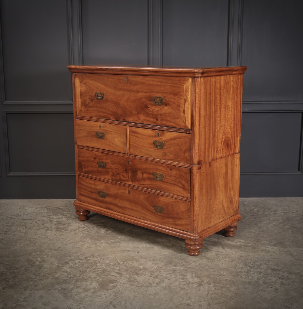 A Victorian camphor wood military campaign secretaire chest featuring brass flush recessed handles and turned feet.