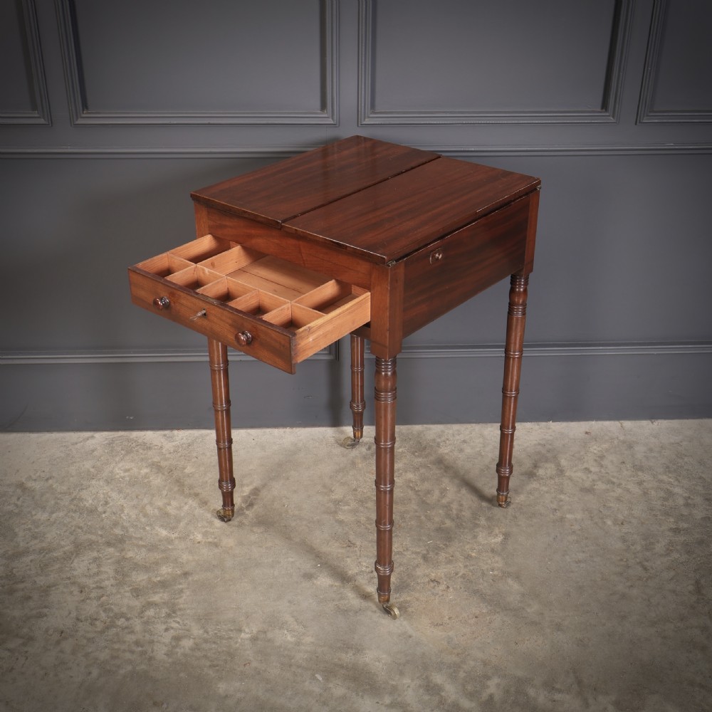 An antique Regency mahogany writing table featuring an adjustable leather-lined ratcheted reading slope, drop side flaps, a single drawer, and ring-turned legs with brass castors. View VI