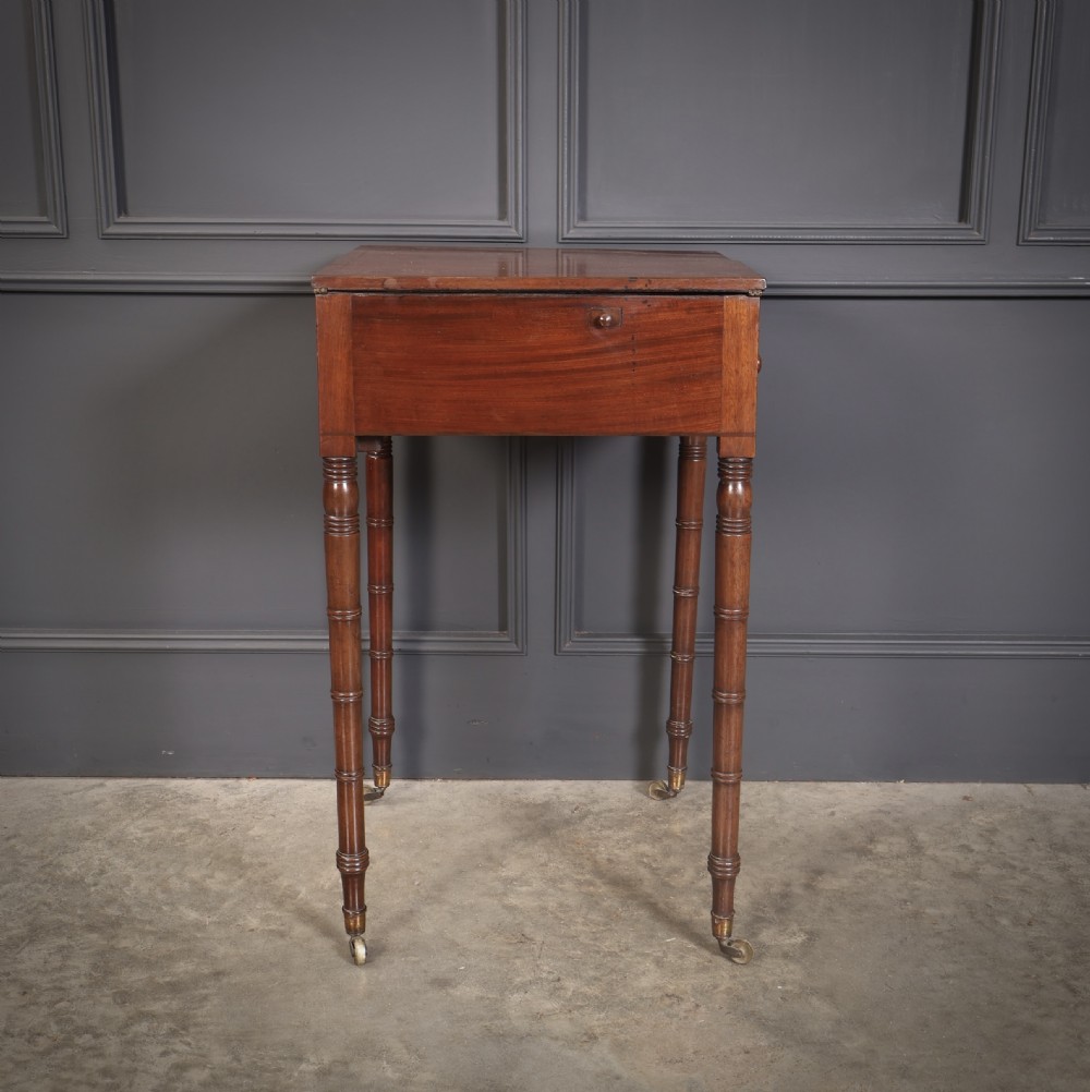 An antique Regency mahogany writing table featuring an adjustable leather-lined ratcheted reading slope, drop side flaps, a single drawer, and ring-turned legs with brass castors. View VIII