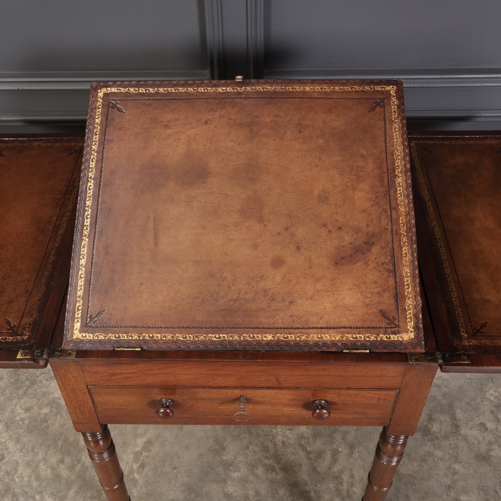 An antique Regency mahogany writing table featuring an adjustable leather-lined ratcheted reading slope, drop side flaps, a single drawer, and ring-turned legs with brass castors. View XIII