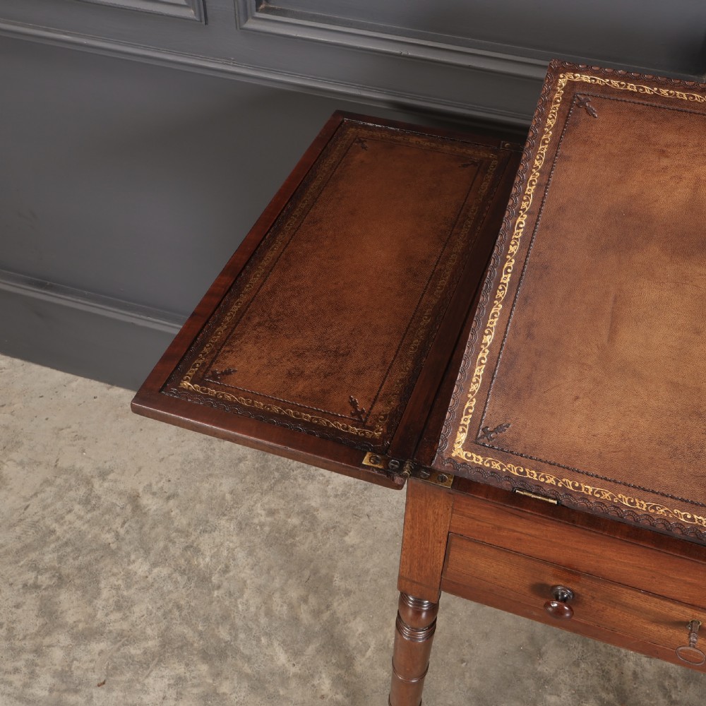 An antique Regency mahogany writing table featuring an adjustable leather-lined ratcheted reading slope, drop side flaps, a single drawer, and ring-turned legs with brass castors. View XIV