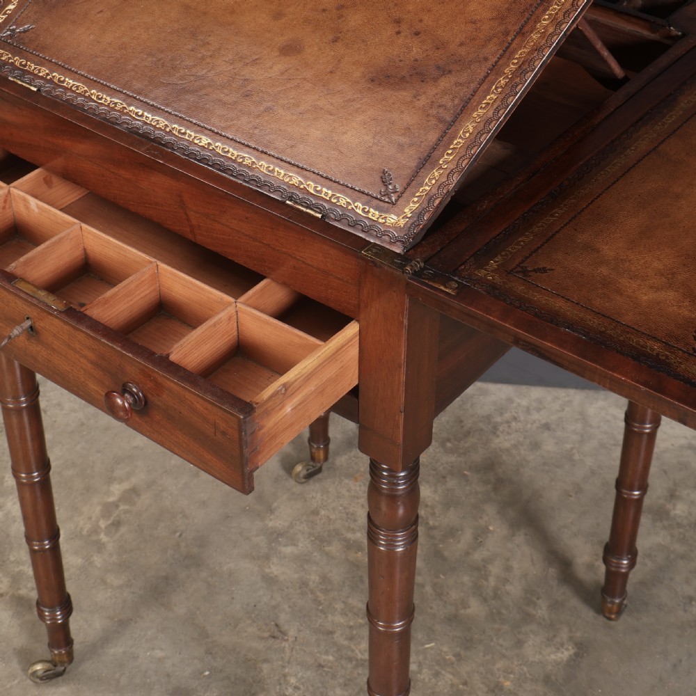 An antique Regency mahogany writing table featuring an adjustable leather-lined ratcheted reading slope, drop side flaps, a single drawer, and ring-turned legs with brass castors. View XVI