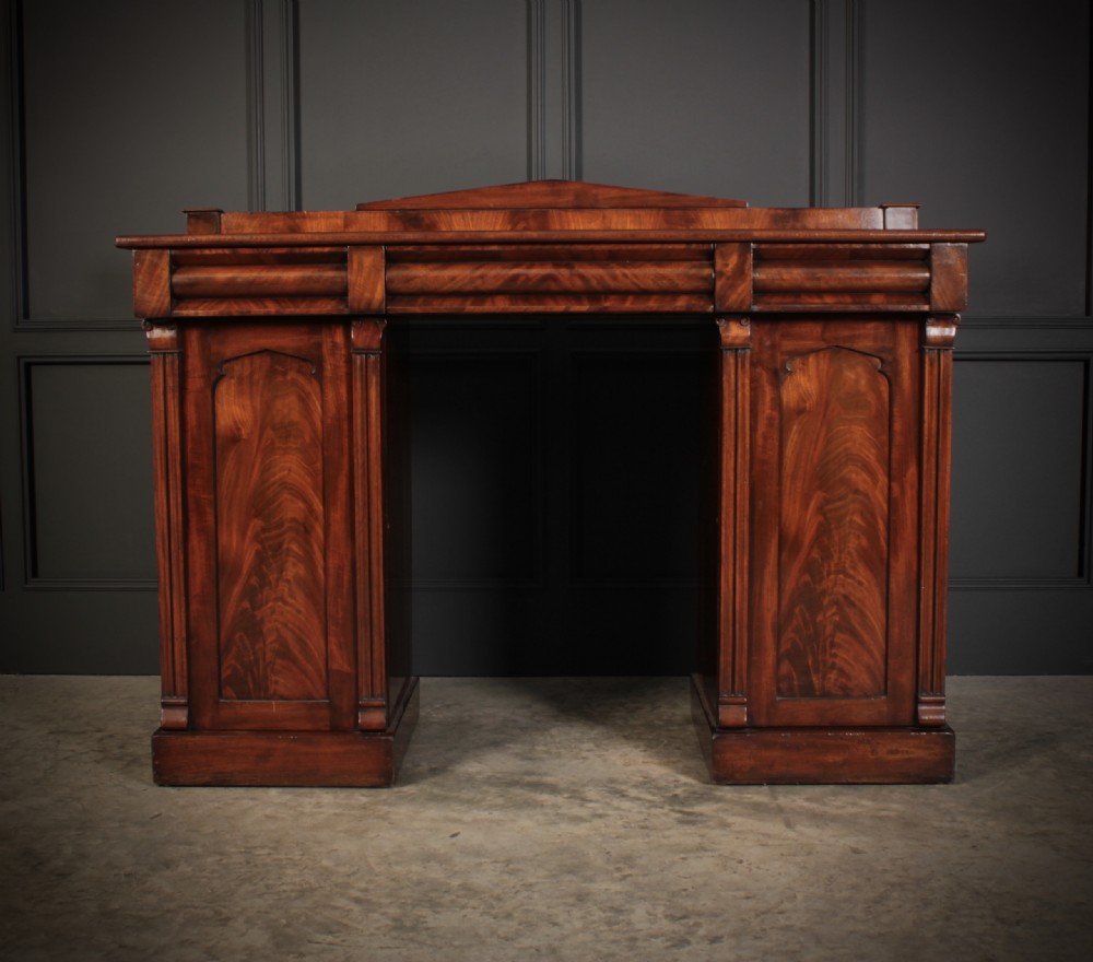 A 19th-century flame mahogany pedestal sideboard featuring two cupboard bases, an arched backboard rail, and fluted pilasters. View II