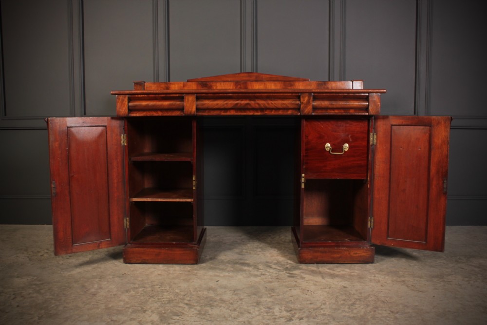 A 19th-century flame mahogany pedestal sideboard featuring two cupboard bases, an arched backboard rail, and fluted pilasters. View III