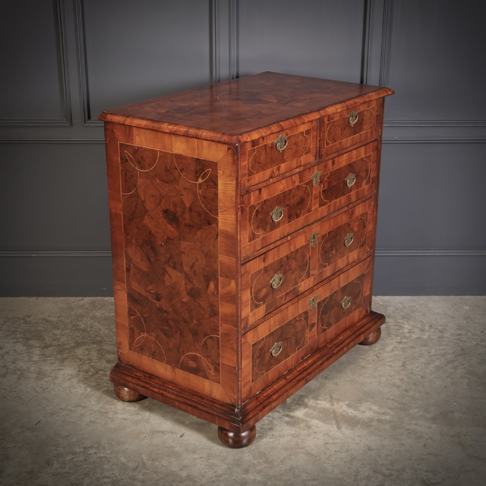 A William and Mary period chest of drawers with decorative oyster veneering, stringing inlay, brass teardrop handles, and turned bun feet. View II