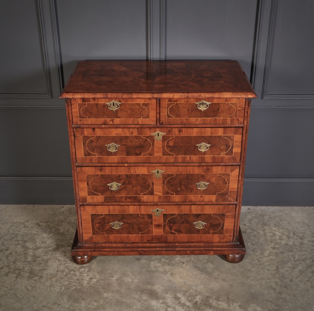A William and Mary period chest of drawers with decorative oyster veneering, stringing inlay, brass teardrop handles, and turned bun feet. View III