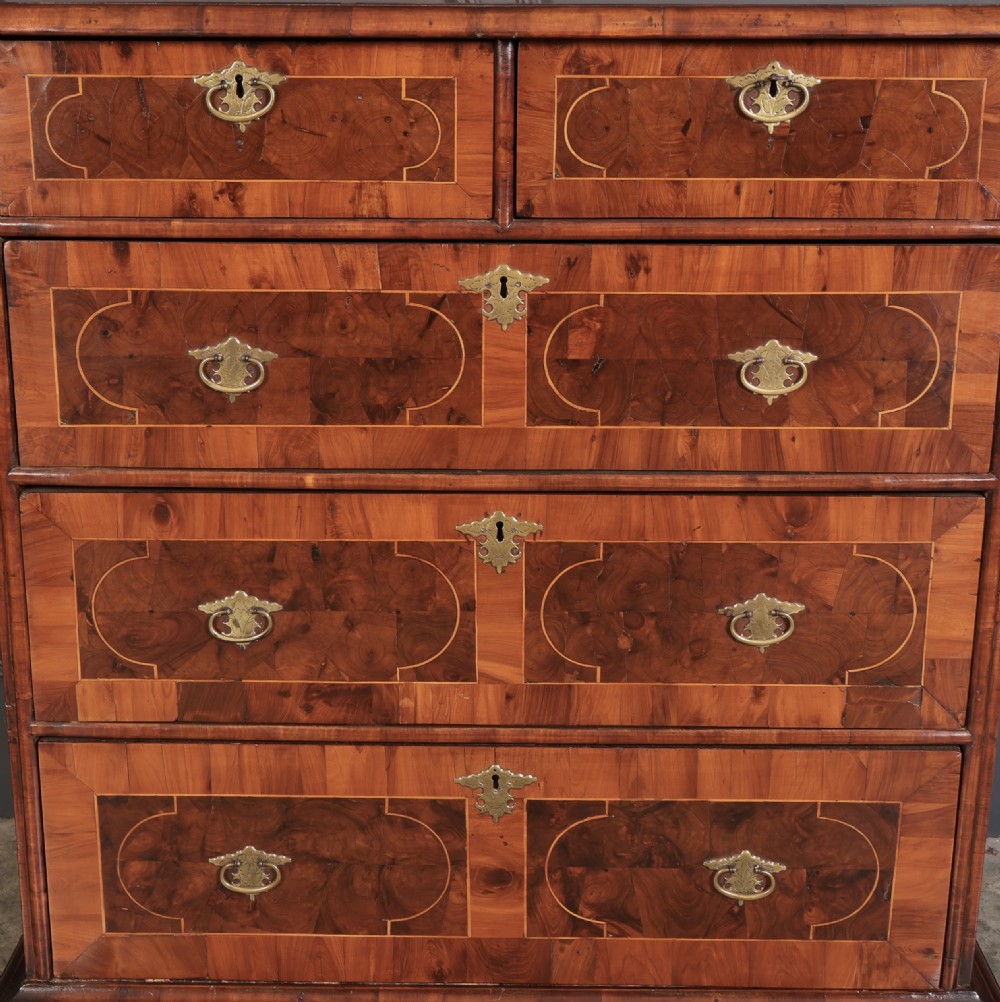 A William and Mary period chest of drawers with decorative oyster veneering, stringing inlay, brass teardrop handles, and turned bun feet. View VII