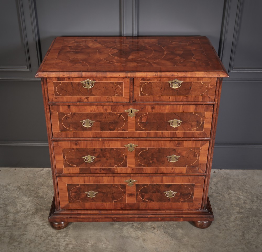 A William and Mary period chest of drawers with decorative oyster veneering, stringing inlay, brass teardrop handles, and turned bun feet. View VIII