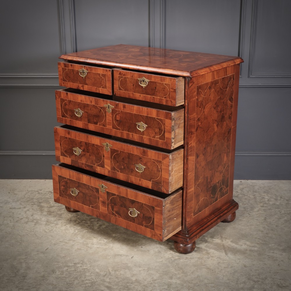 A William and Mary period chest of drawers with decorative oyster veneering, stringing inlay, brass teardrop handles, and turned bun feet. View XII