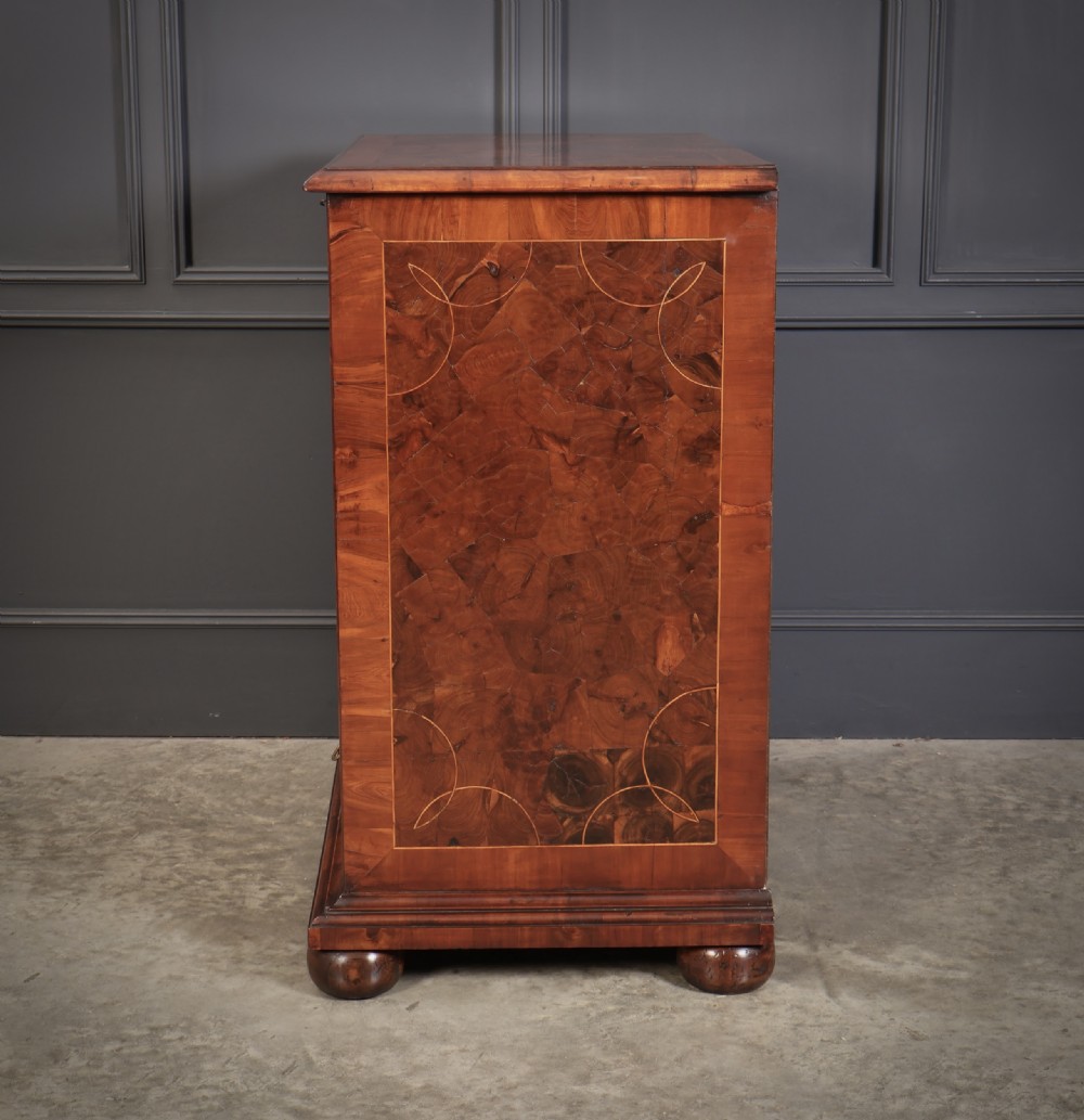 A William and Mary period chest of drawers with decorative oyster veneering, stringing inlay, brass teardrop handles, and turned bun feet. View XIII