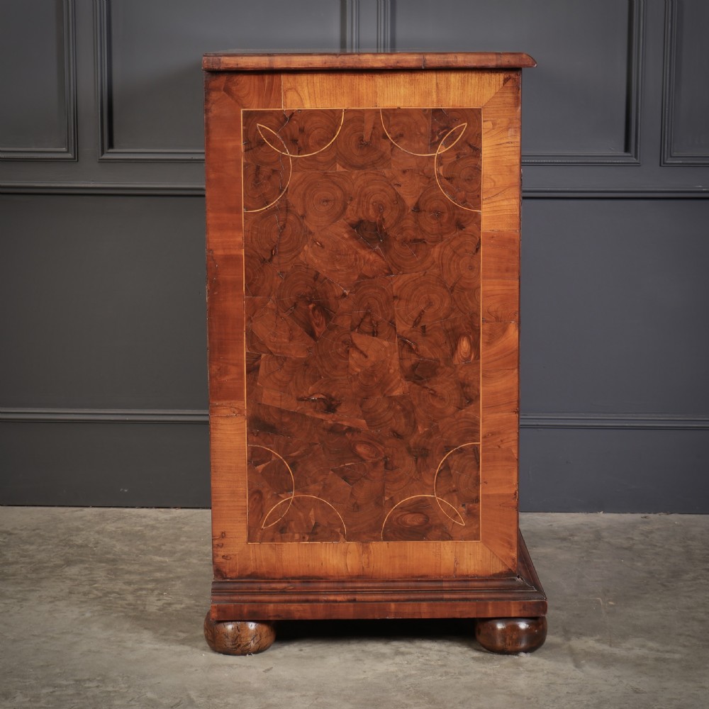 A William and Mary period chest of drawers with decorative oyster veneering, stringing inlay, brass teardrop handles, and turned bun feet. View XVII