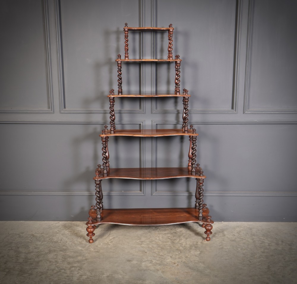 A Victorian rosewood six-tier whatnot stand featuring graduated open shelves supported by barley twist columns and topped with turned finials. View VI
