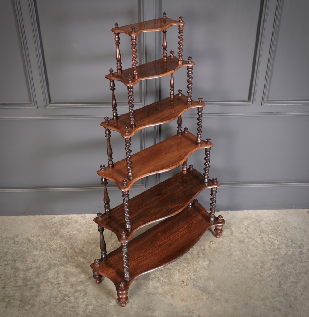 A Victorian rosewood six-tier whatnot stand featuring graduated open shelves supported by barley twist columns and topped with turned finials. View VII