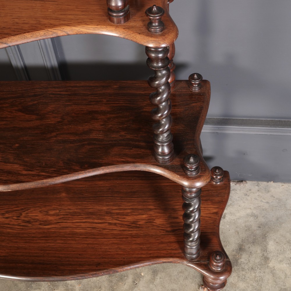 A Victorian rosewood six-tier whatnot stand featuring graduated open shelves supported by barley twist columns and topped with turned finials. View VIII