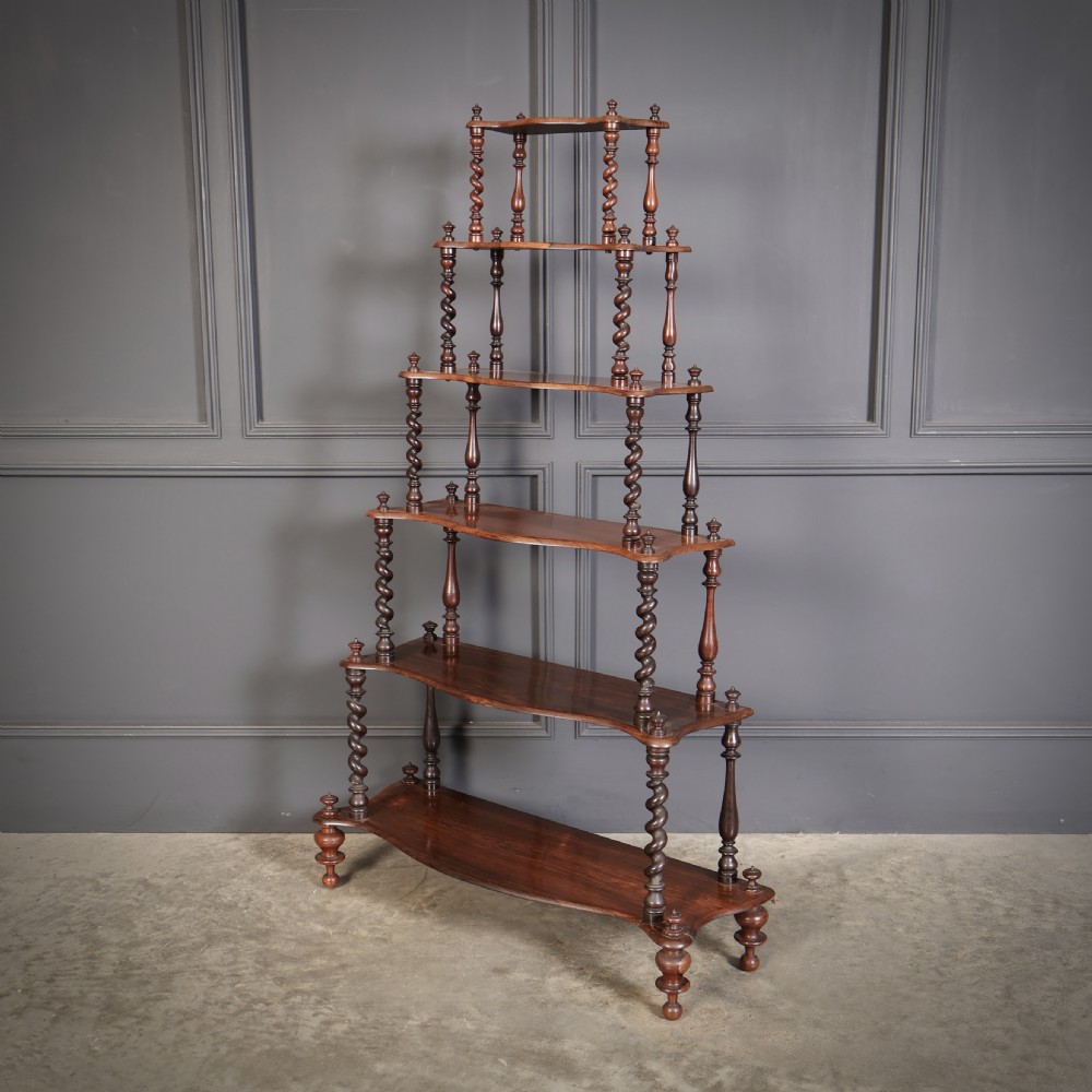 A Victorian rosewood six-tier whatnot stand featuring graduated open shelves supported by barley twist columns and topped with turned finials. View X