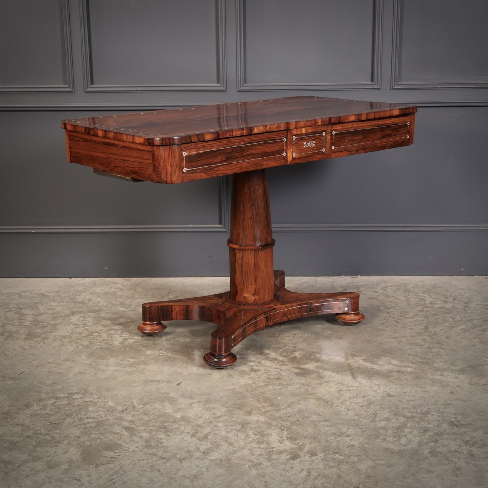 A Regency rosewood library table featuring brass stringing, dot inlays, frieze drawers, and a central pedestal support on a four-star base. View III