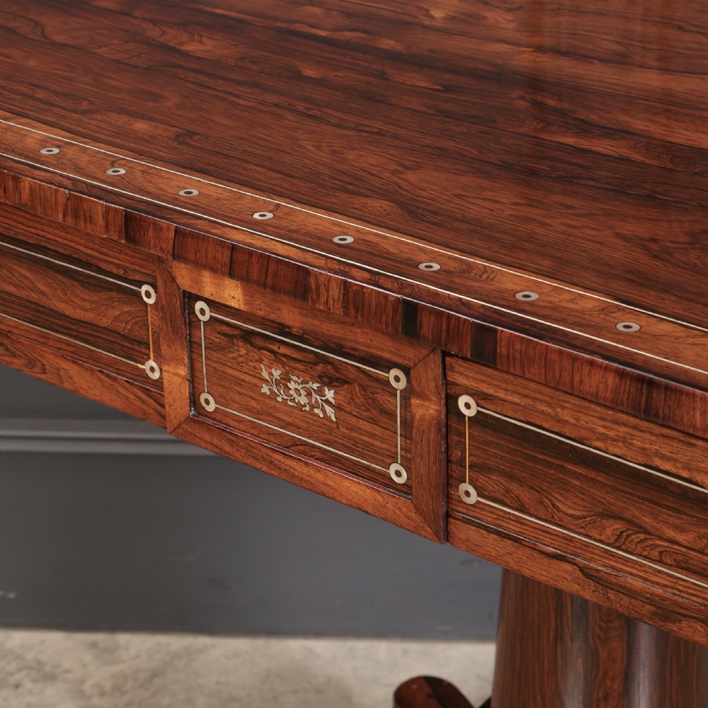 A Regency rosewood library table featuring brass stringing, dot inlays, frieze drawers, and a central pedestal support on a four-star base. View XIII