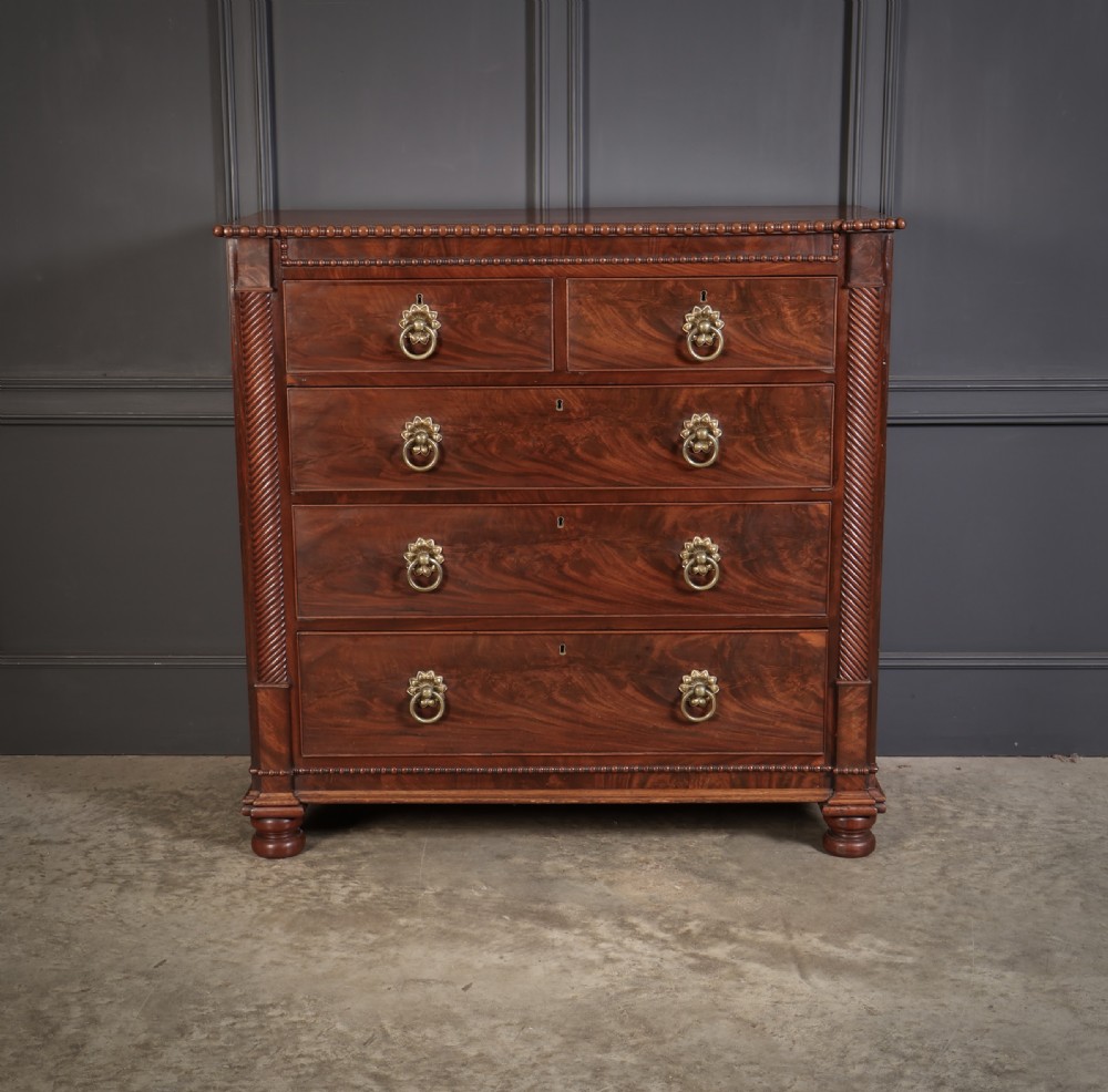 A nineteenth-century Scottish flame mahogany chest of drawers featuring twist-turned side columns, five graduated drawers with brass ring handles, and turned feet. View III