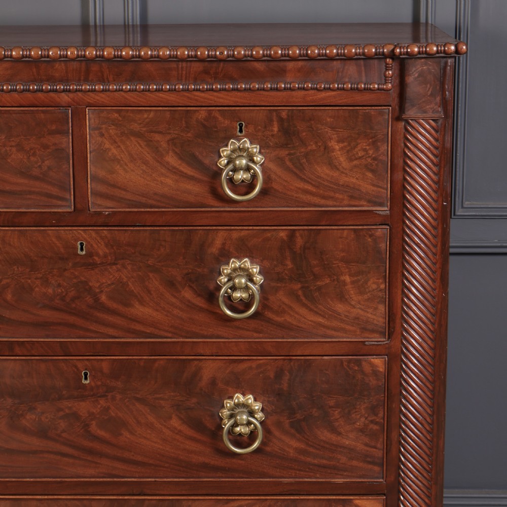 A nineteenth-century Scottish flame mahogany chest of drawers featuring twist-turned side columns, five graduated drawers with brass ring handles, and turned feet. View VI