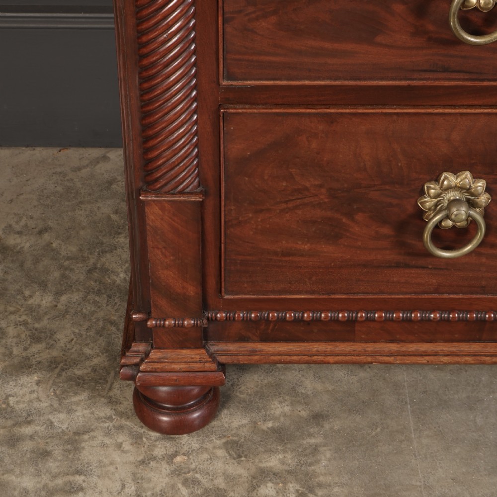 A nineteenth-century Scottish flame mahogany chest of drawers featuring twist-turned side columns, five graduated drawers with brass ring handles, and turned feet. View VIII