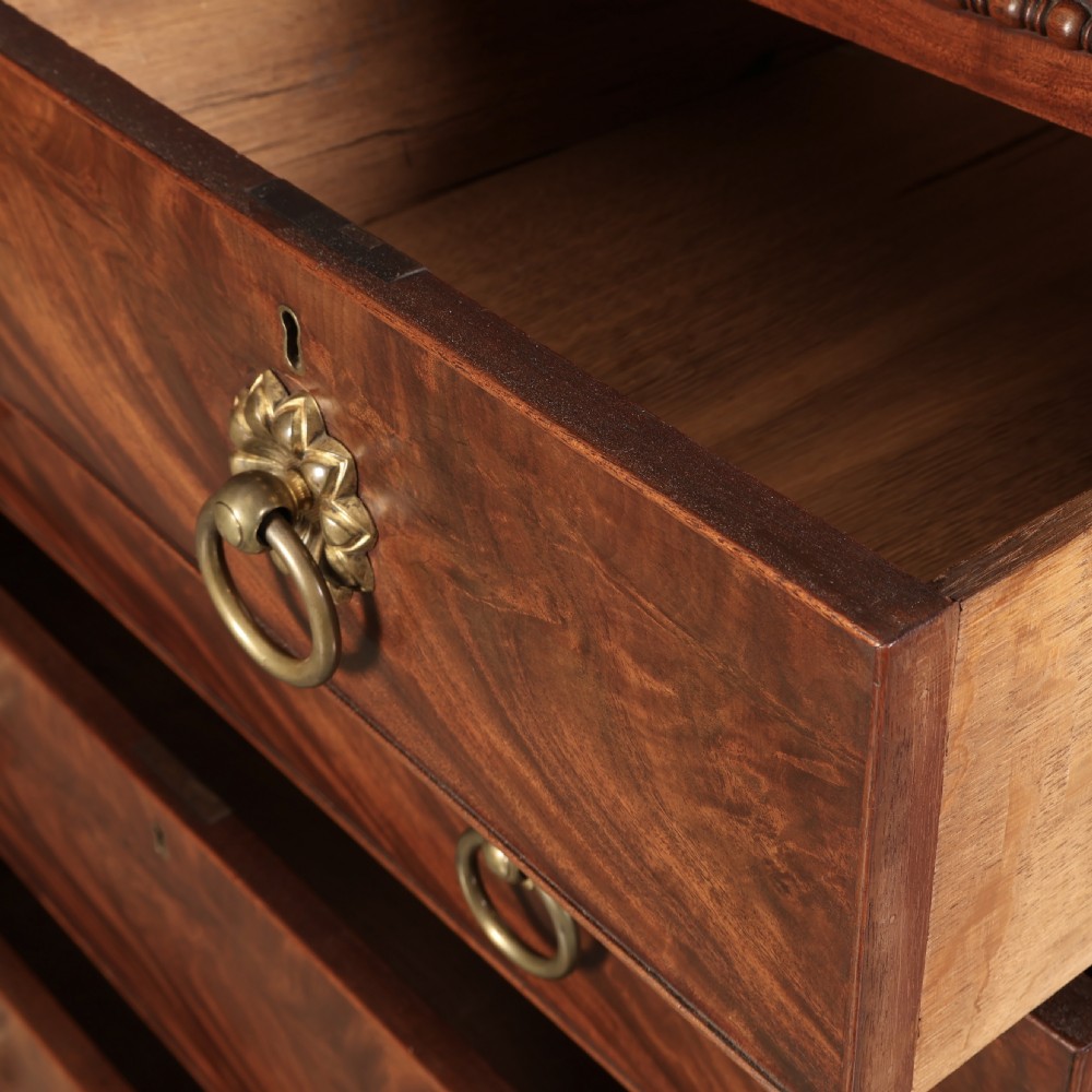 A nineteenth-century Scottish flame mahogany chest of drawers featuring twist-turned side columns, five graduated drawers with brass ring handles, and turned feet. View XII