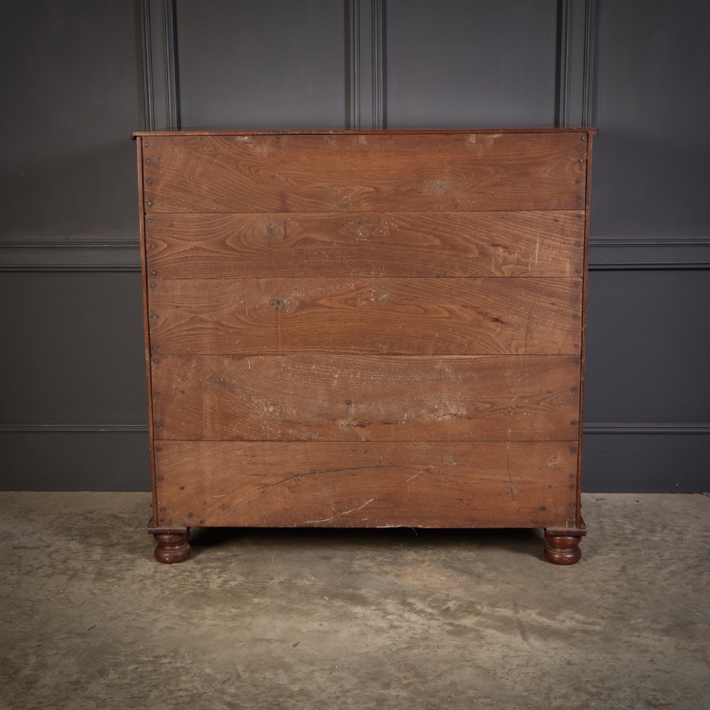 A nineteenth-century Scottish flame mahogany chest of drawers featuring twist-turned side columns, five graduated drawers with brass ring handles, and turned feet. View XIV