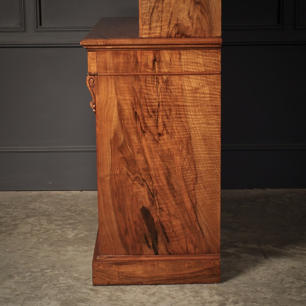 A two-part William IV walnut bookcase featuring upper and lower glazed doors with carved corbel accents and a plinth base. View XIV