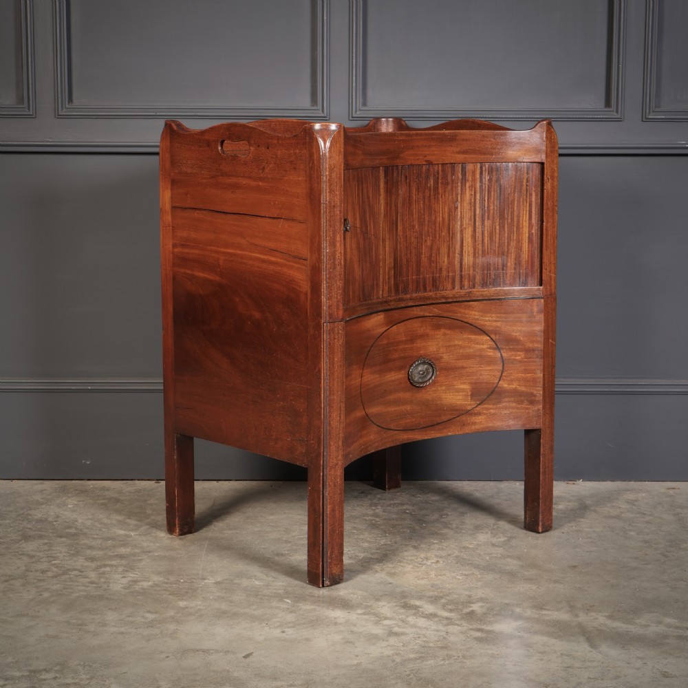 A George III mahogany nightstand featuring a gallery top, concave front with a tambour door, and a single lower drawer with oval inlay. View V