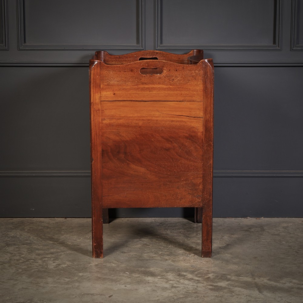 A George III mahogany nightstand featuring a gallery top, concave front with a tambour door, and a single lower drawer with oval inlay. View IX