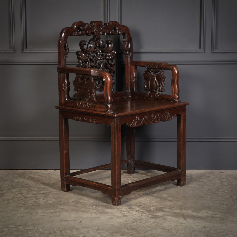 A pair of traditional Chinese dark hardwood Hongmu armchairs with intricately carved openwork back panels and rectangular seats. View III