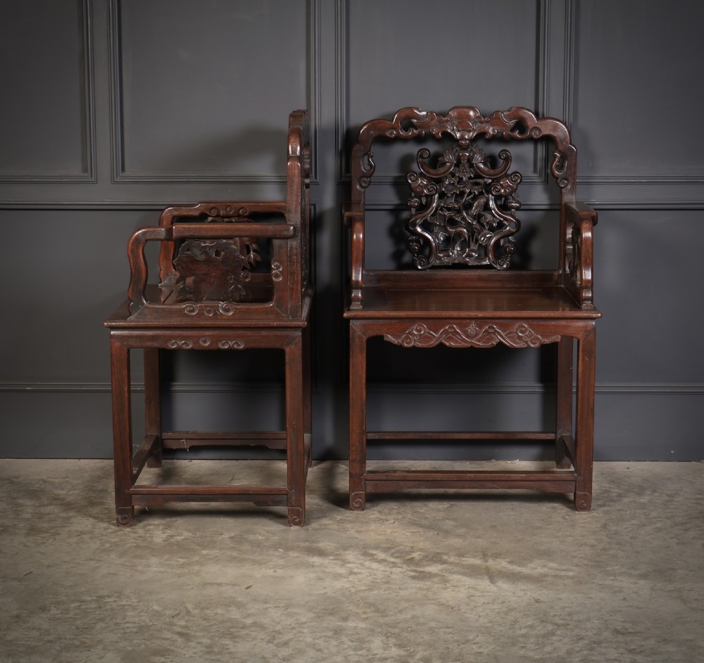 A pair of traditional Chinese dark hardwood Hongmu armchairs with intricately carved openwork back panels and rectangular seats. View V