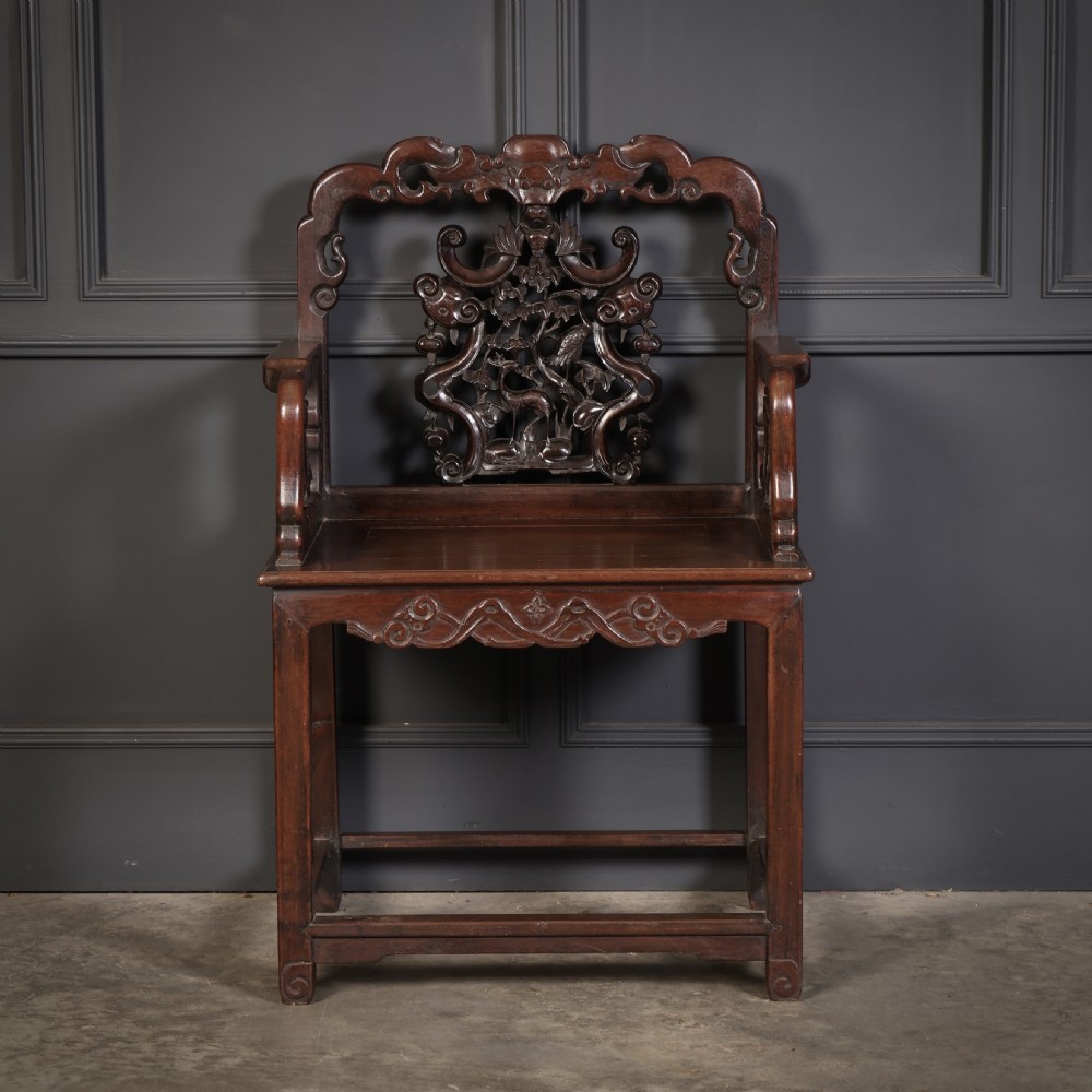 A pair of traditional Chinese dark hardwood Hongmu armchairs with intricately carved openwork back panels and rectangular seats. View VII