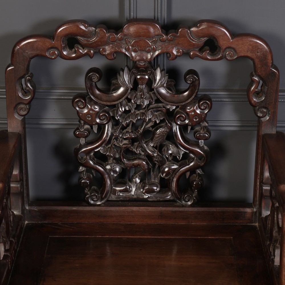 A pair of traditional Chinese dark hardwood Hongmu armchairs with intricately carved openwork back panels and rectangular seats. View VIII
