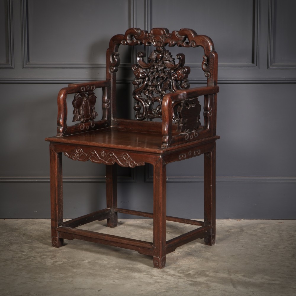 A pair of traditional Chinese dark hardwood Hongmu armchairs with intricately carved openwork back panels and rectangular seats. View IX