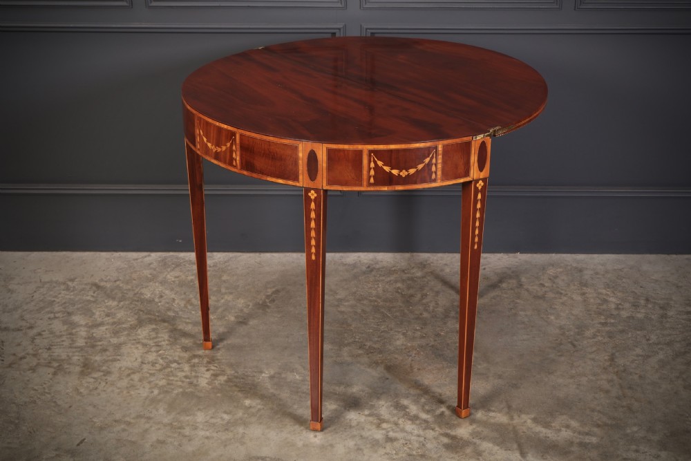 An 18th-century demilune tea table made of dark mahogany with satinwood marquetry inlays featuring a fan motif and tapered legs. View IX