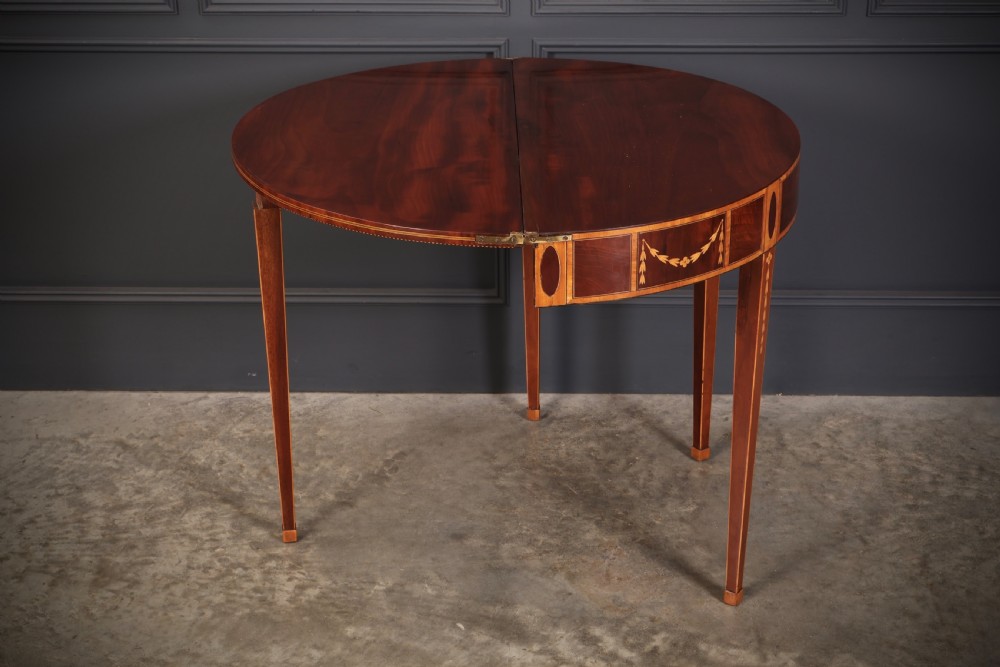 An 18th-century demilune tea table made of dark mahogany with satinwood marquetry inlays featuring a fan motif and tapered legs. View XIV