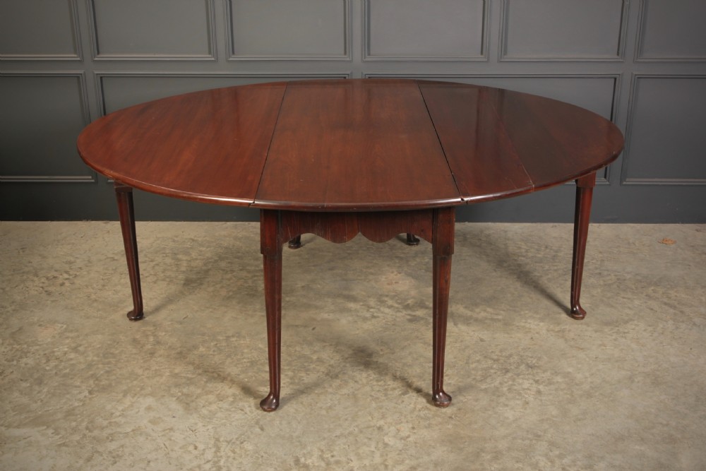An 18th-century Georgian mahogany drop-leaf dining table with an oval top supported by tapered legs with pad feet. View III