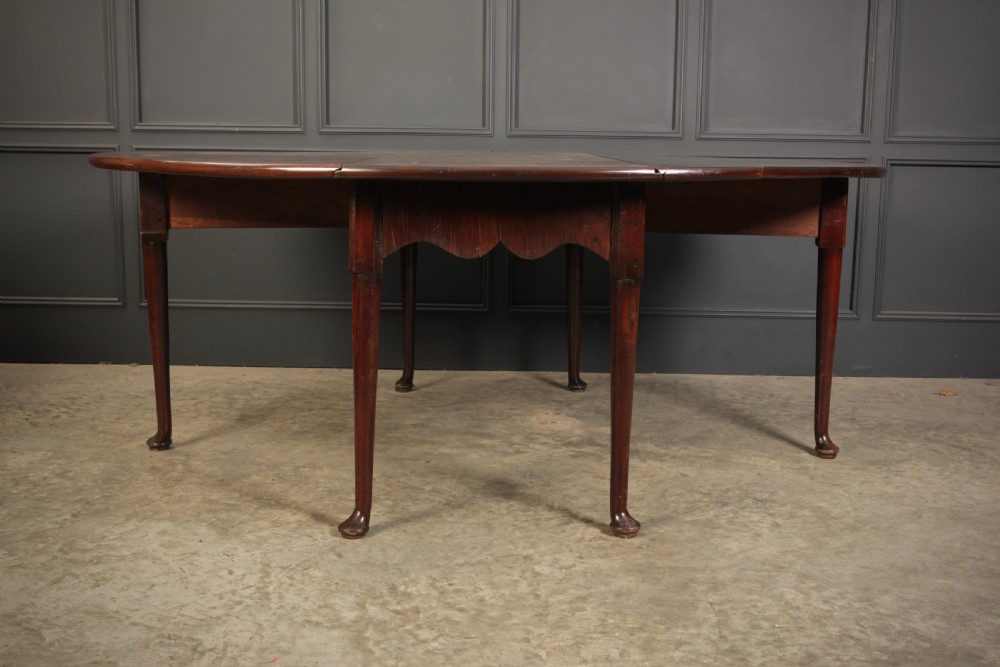 An 18th-century Georgian mahogany drop-leaf dining table with an oval top supported by tapered legs with pad feet. View VI
