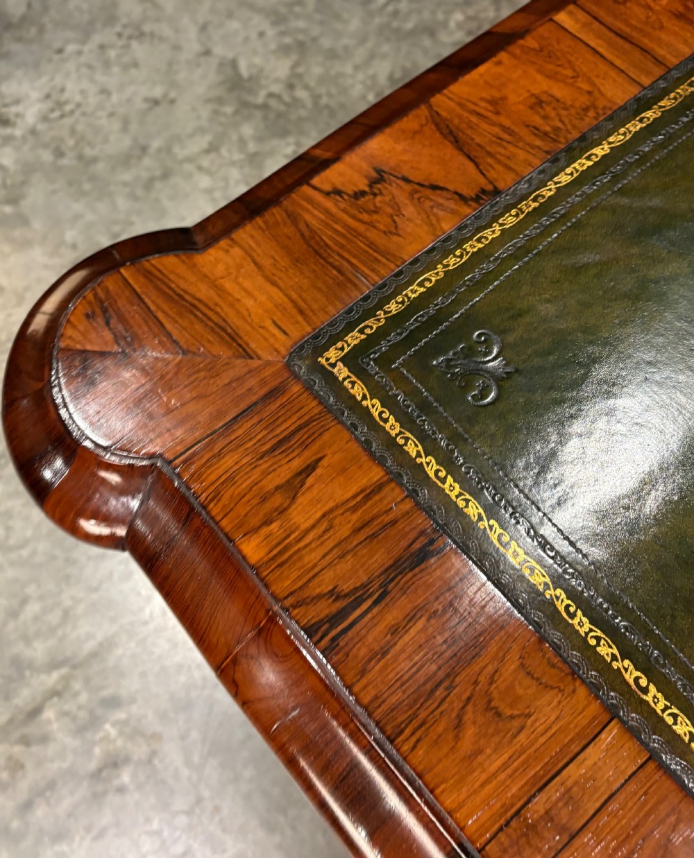 A William IV rosewood partners writing desk featuring a green leather inset top, carved serpentine aprons, and bold cabriole legs ending in carved feet. View VI