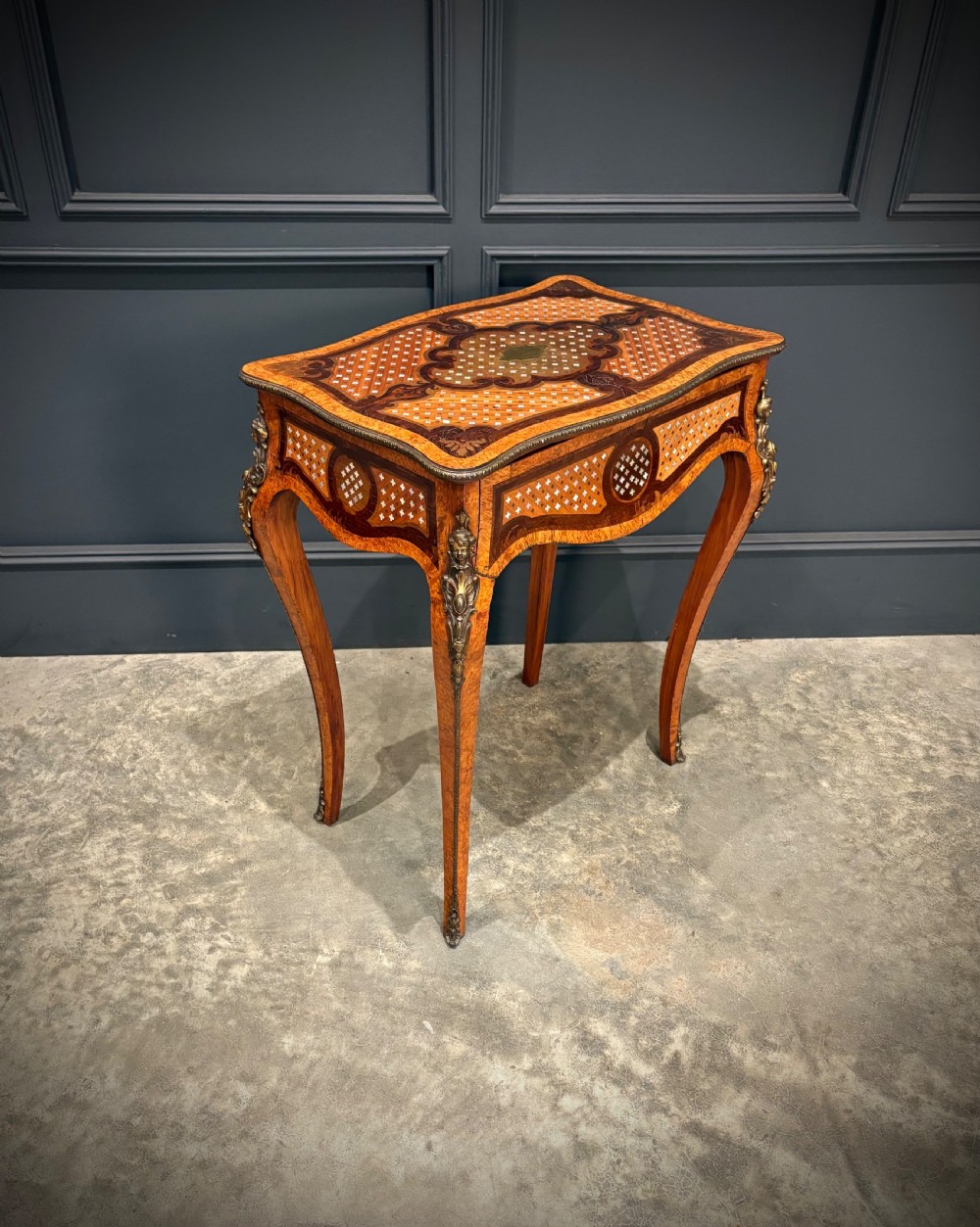 French style side table featuring geometric lattice marquetry inlay, cabriole legs, and gilded bronze ormolu mounts.