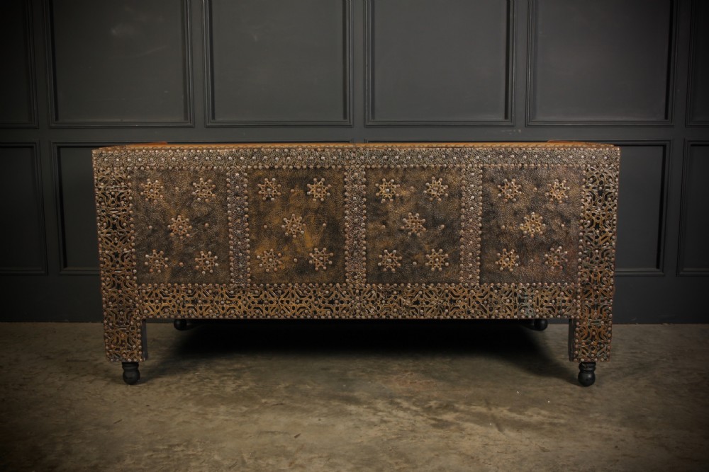 A three-piece Moroccan seating suite comprising a sofa and two armchairs upholstered in tan leather with brass studding and geometric metal trim. View III