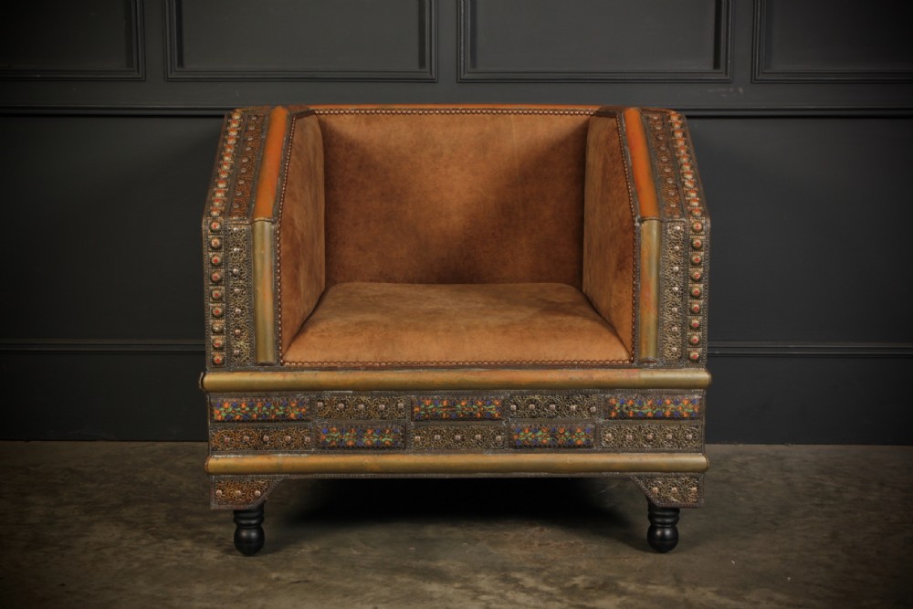 A three-piece Moroccan seating suite comprising a sofa and two armchairs upholstered in tan leather with brass studding and geometric metal trim. View VIII