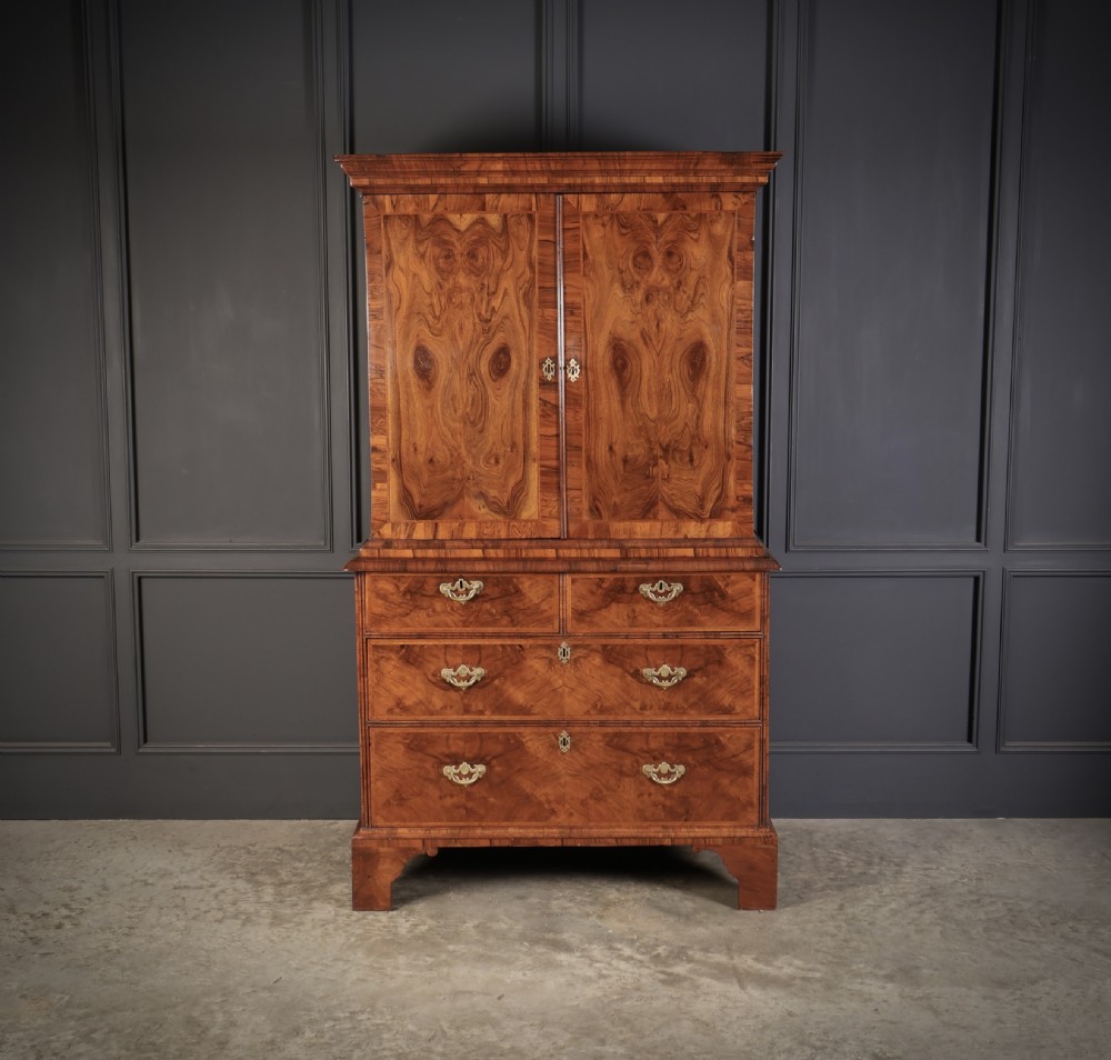 A two-part Queen Anne walnut cabinet on chest featuring upper cupboard doors with bookmatched timber grain and a lower chest with four drawers on bracket feet. View II