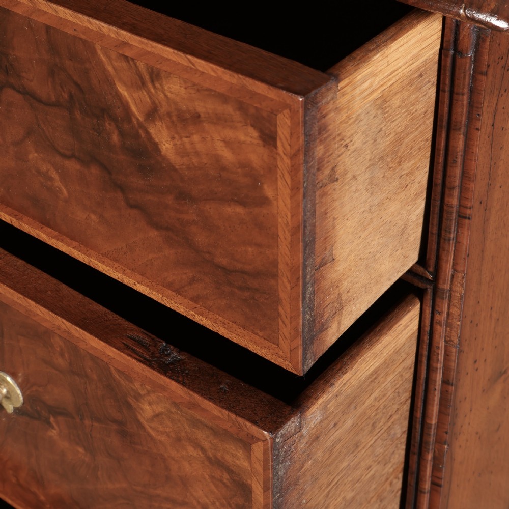A two-part Queen Anne walnut cabinet on chest featuring upper cupboard doors with bookmatched timber grain and a lower chest with four drawers on bracket feet. View IX
