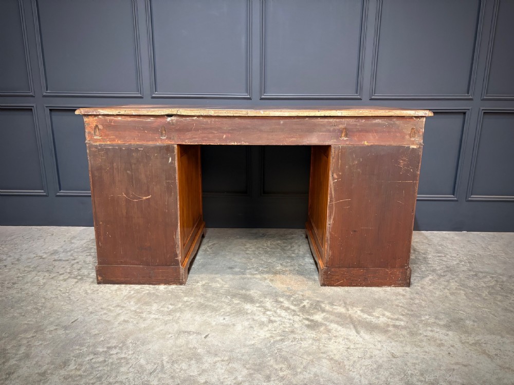 An antique burr walnut pedestal desk featuring inlaid feather-banded borders, brass drop handles, and multiple side drawers. View XIII
