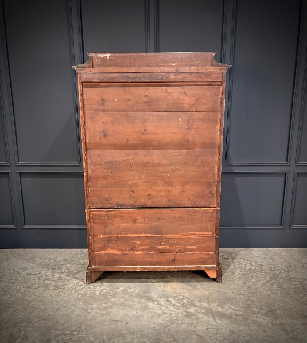 A tall 19th-century burr walnut chest of drawers featuring seven graduated drawers with brass escutcheons and ebonised mouldings set on turned front feet. View IX