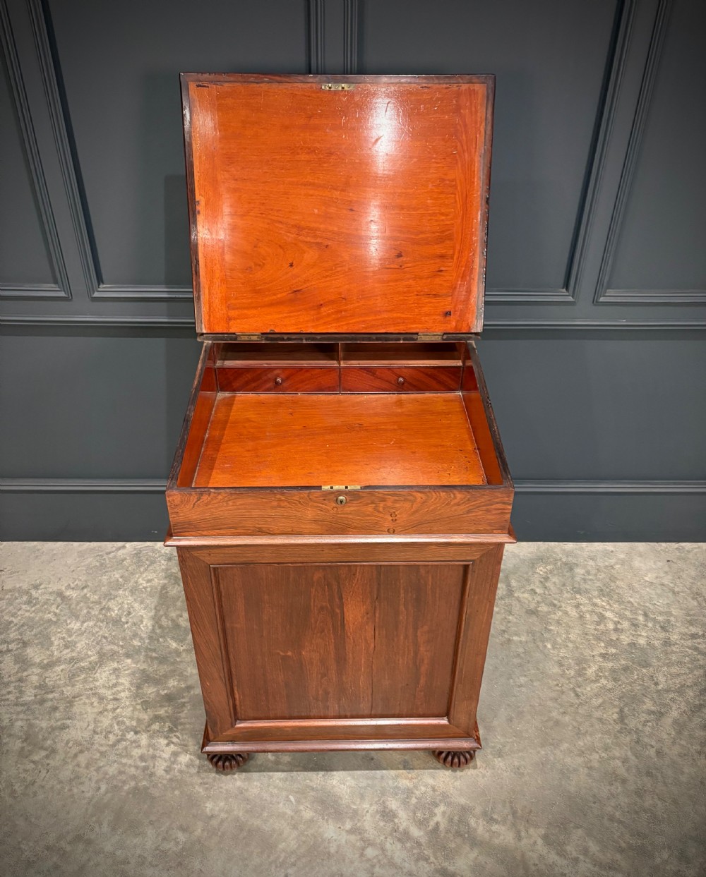 A 19th-century rosewood Davenport desk featuring a sloped writing top inset with dark green tooled leather, a spindled gallery rail, and stacked drawers. View VII