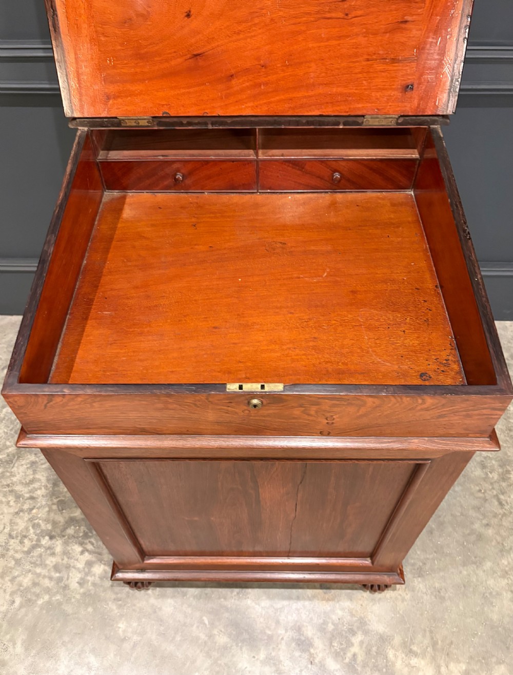 A 19th-century rosewood Davenport desk featuring a sloped writing top inset with dark green tooled leather, a spindled gallery rail, and stacked drawers. View VIII