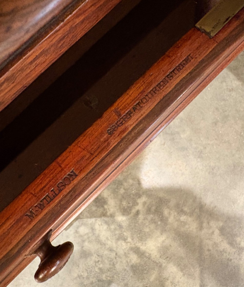 A 19th-century rosewood Davenport desk featuring a sloped writing top inset with dark green tooled leather, a spindled gallery rail, and stacked drawers. View X
